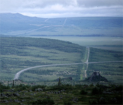 The Dalton Highway and Alaska Pipeline crisscross the low rolling taiga south of the Brooks Range, by Nick Lawrence